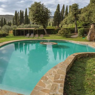 piscina a forma libera, telo grigio, gradini e fontana